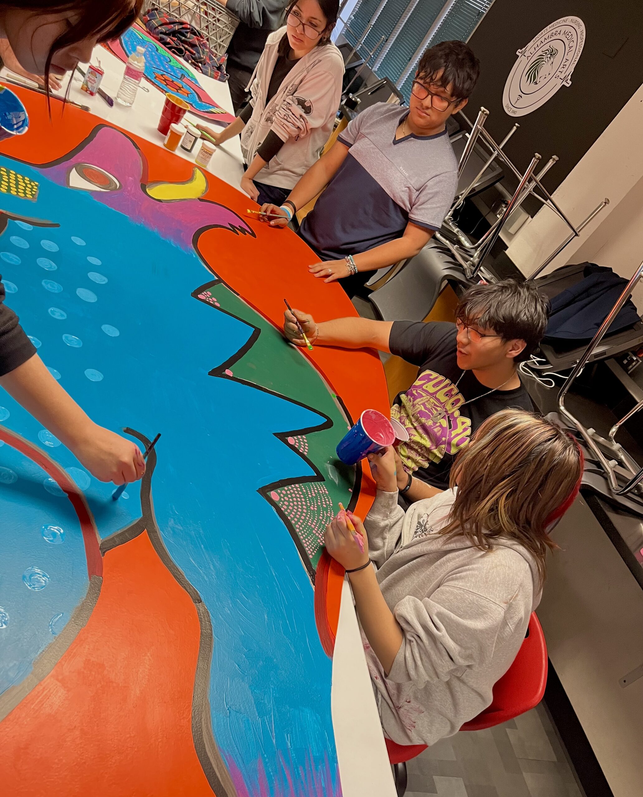 MEChA students painting an Alebrije